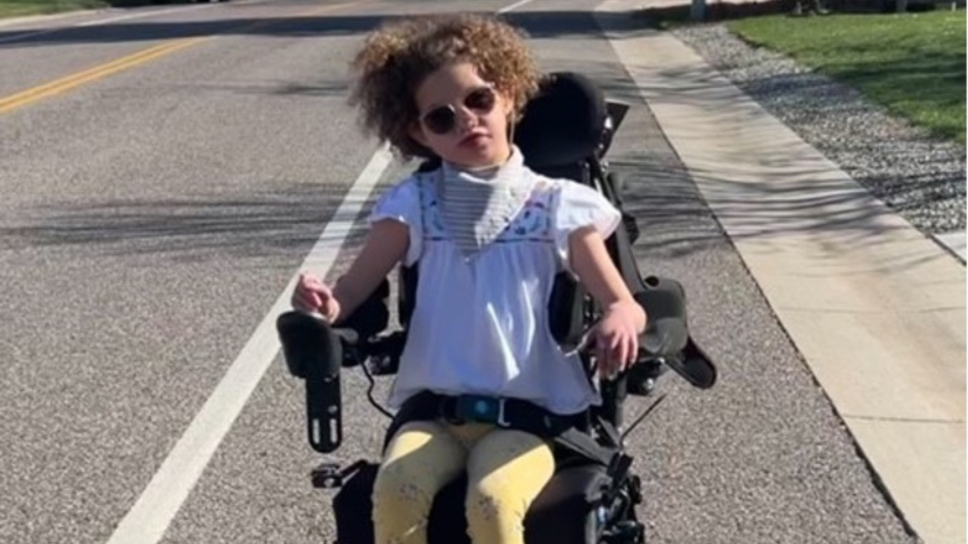 Jordy in her chair Jordy rides down a neighborhood street in her new chair